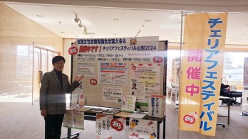 チェリアフェスティバル開催中のパネルの前に立つ萩原なつ子の写真
