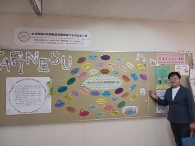 展示を指す萩原なつ子の写真