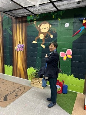 猿の絵を指す萩原なつ子の写真