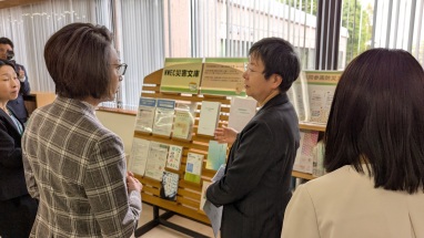 NWEC災害文庫コーナーで萩原なつ子が三原大臣に説明している写真