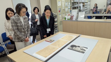 三原大臣が机に置かれた史料を見ている写真