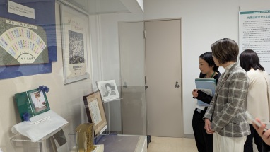三原大臣がガラスケースに展示された史料を見ている写真